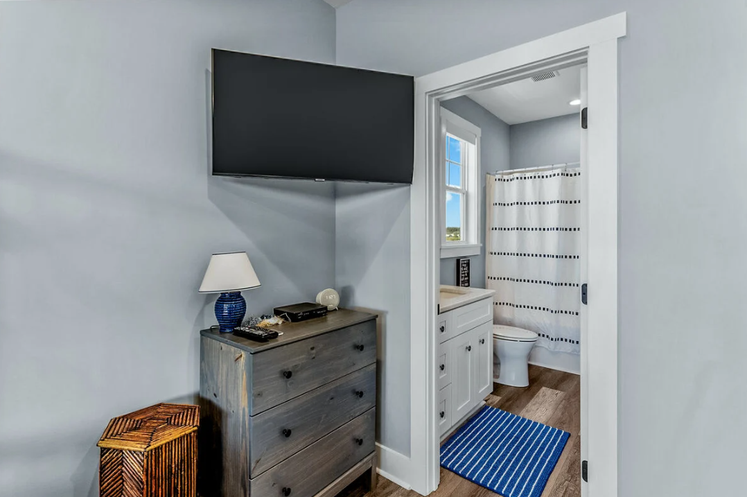 Bunk bedroom with TV, dresser, and en-suite bath
