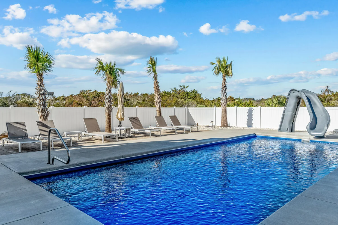 Private pool with lounge chairs and palm trees