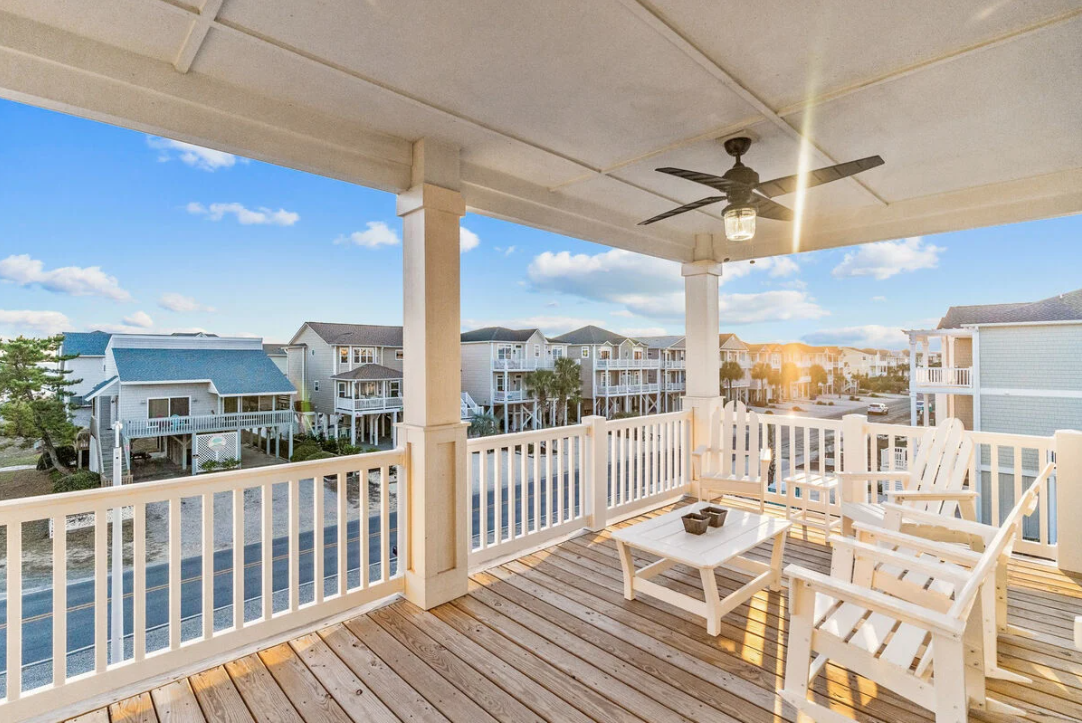 Upper front porch with seating and ceiling fan