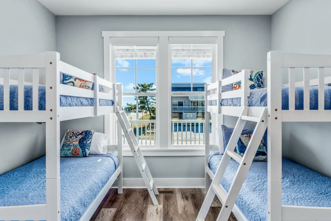 Bunk bedroom with four twin beds and window views